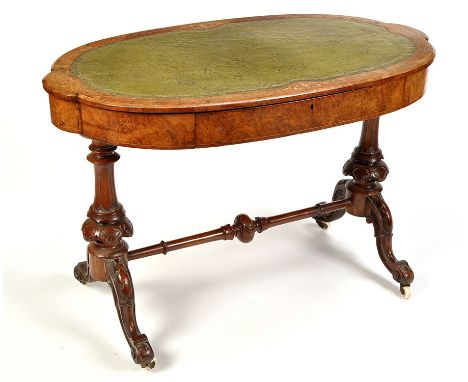 A Victorian oval-shaped burr walnut writing table, with inset tooled green leather writing surface, the edge decorated with i