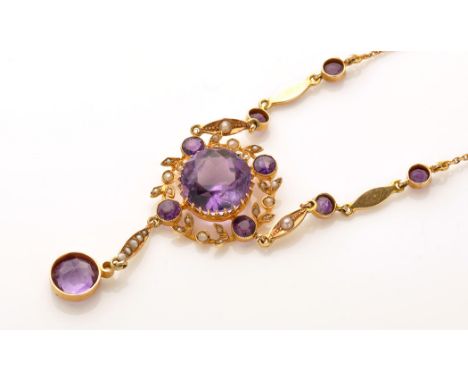 An Edwardian amethyst, seed pearl and yellow metal necklace, the central circular facet cut amethyst surrounded by a wreath o