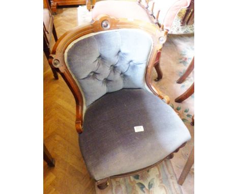 WALNUT LOW ARMCHAIR. Walnut framed upholstered low armchair with ceramic castors