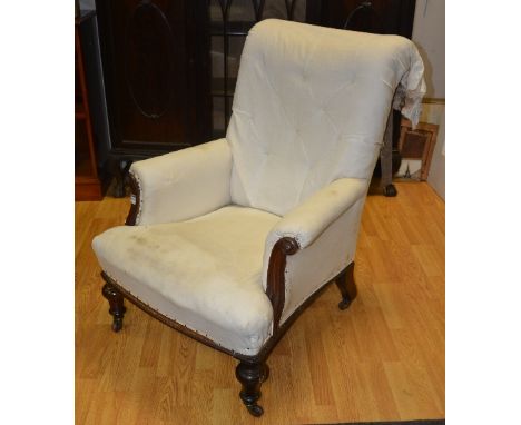A Victorian mahogany framed library armchair, upholstered in later white fabric (a/f), raised on scroll columns and turned su