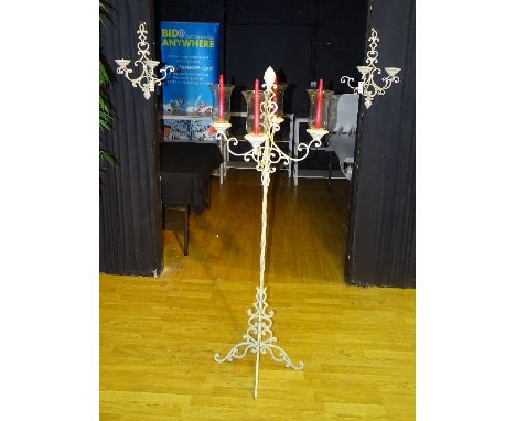 A painted wrought iron floor lamp, with four branches having glass shades, 161cm high, together with a pair of matching wall 
