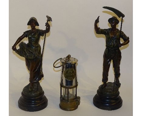 A pair of French spelter figures after Guillemin, male and female, both with labels for Retour des Champs, Moissonneur, raise