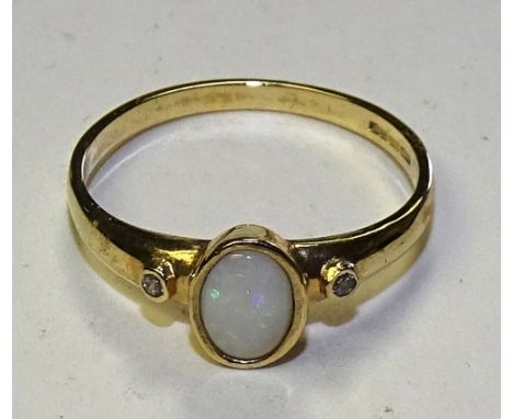 A 9ct gold opal and diamond ring, the central cabochon opal flanked by small milidiamond to either shoulder, stamped 375, rin