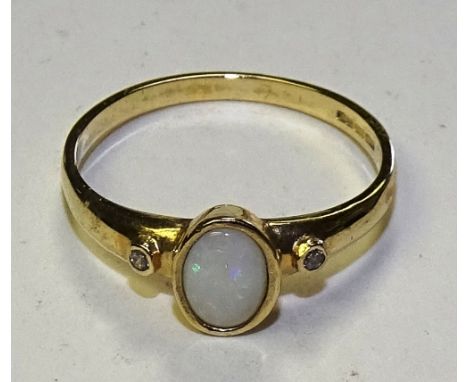 A 9ct gold opal and diamond ring, the central cabochon opal flanked by small milidiamond to either shoulder, stamped 375, rin