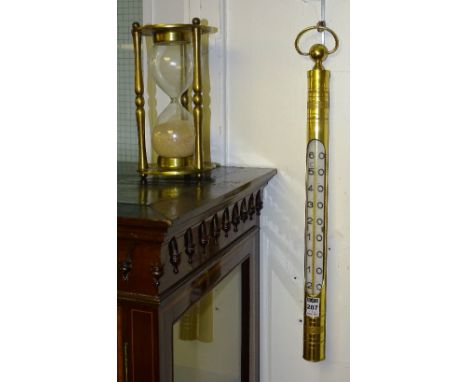 A gilt metal cased wall hanging stick thermometer, with ring carry handle, 54cm long, together with a gilt metal and glass de