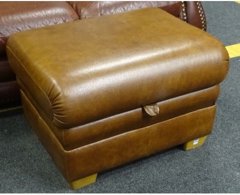 A modern brown leather pouffe stool, the hinged top enclosing storage space, raised on wood supports, 42cm high x 77cm wide