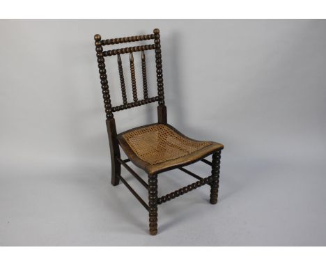 A 19th Century Slipper Chair with Bobbin Turned Back over a Caned Seat, 80cms High 
