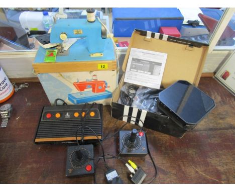 A vintage Atari console, a boxed child's toy sewing machine and a HD PUR 2 gaming edition 