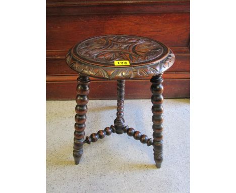 A late Victorian oak stool with a carved top, raised on bobbin turned legs 