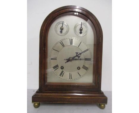 An early 20th century mahogany, arched topped cased mantle clock by Winterhalder & Hoffmeier, having a silvered dial and chap