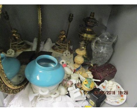 Mixed china, christening gowns, a brass oil lamp, converted, two other table lamps, an oval gilt mirror, a cut glass water ju