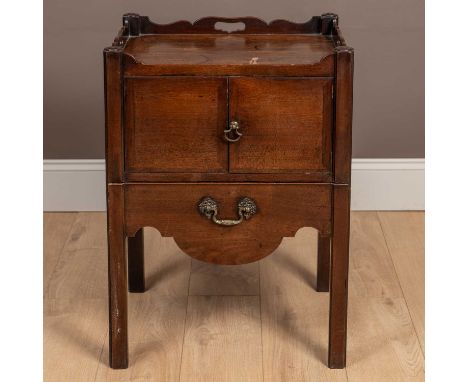 A Georgian mahogany commode, the galleried top with pierced handles, cupboard doors and a lead line pull-out lower section wi