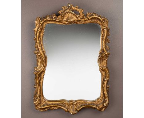 a gilt wall rococo style wall mirror with a C scrolled frame surmounted by a shell  55 x 40cm  some loses to the plaster arou