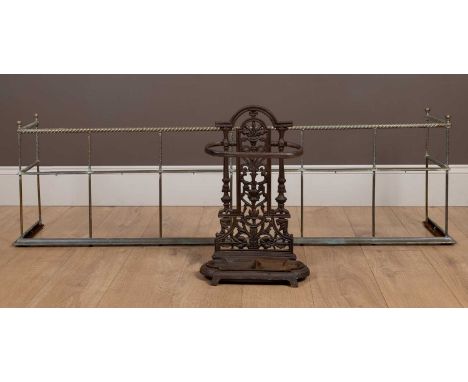 The umbrella stand with decorative pierced ornament together with an antique brass fenderthe fender 149cm wide; the umbrella 