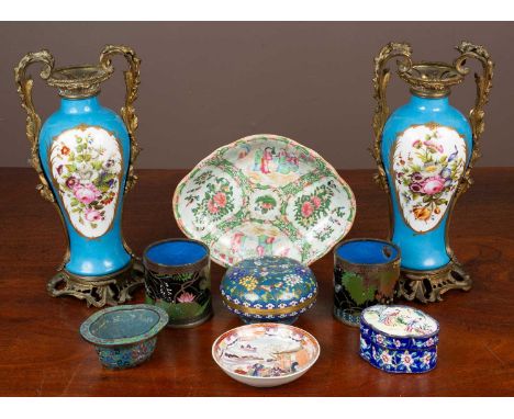 A pair of Sevres style baluster vases with brass mounted handles on a Rococo style brass base with central cartouches decorat