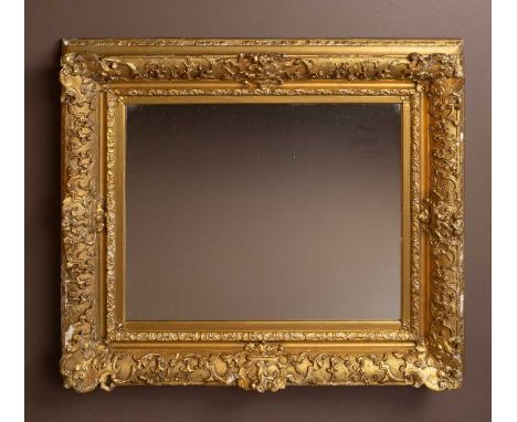 A gilt-framed wall mirror with arabesque plaster moulding77.5 x 68cmSome losses to the frame the back has been replaced