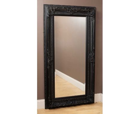 A large mirror in an ornate black frame with acanthus leaf moulding and a bevelled plate184cm x 98cmSome chipping to the moul