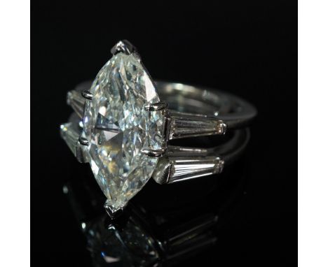 This exceptional platinum engagement ring set features a breathtaking 5.49-carat marquise brilliant-cut diamond, certified by