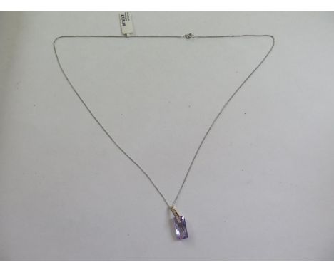 A 9ct yellow gold amethyst pendant, 2cm long on a 9ct white gold chain - total weight approx 2.7 grams - ex jewellers stock, 