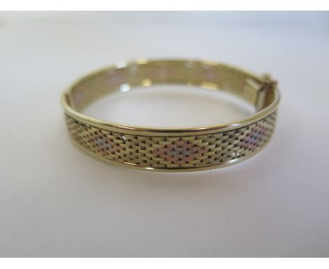 A 9ct tri gold bangle, stamped 375, 6cm oval, approximately 16.7g, please see images for condition 