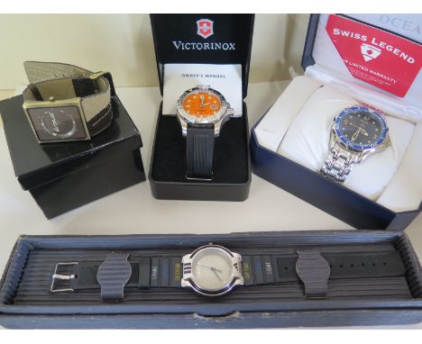 A Victorinox Swiss Army Sports wristwatch with orange face and date calendar, together with three other sports wrist watches,