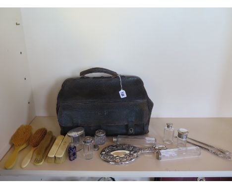 A Victorian fitted travel case with eight assorted silver top bottles, a mirror, two button hooks, assorted brushes, match bo