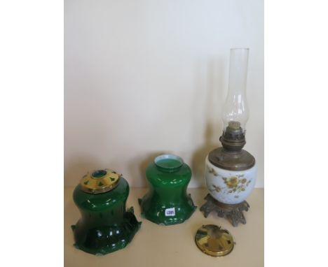 An oil lamp - 54cm H including chimney, and two green glass shades with galleries - 20cm H 