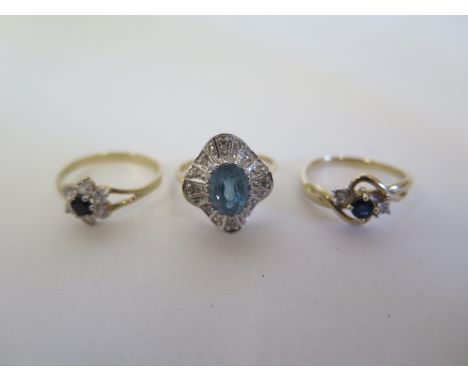 Three 9ct gold rings one with a sapphire style stone flanked on both sides with a single white stone,  please see images for 