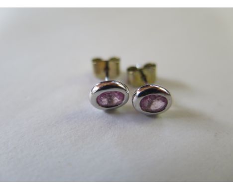 A modern 18ct hallmarked white gold matching pair of stud earrings, each incorporating one rubover set oval mixed cut pink sa