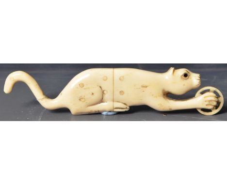 A 19th Century Japanese Meiji period hand carved ivory okimono netsuke depicting a cat. The recumbent cat pivoted in a moving