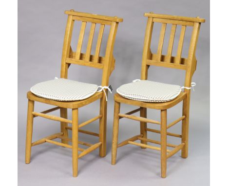 A pair of light oak chapel chairs, each with rail-back &amp; hard seat, on round legs with spindle stretchers. 