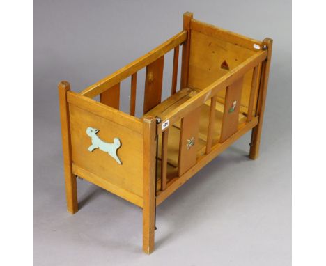 A vintage Tri-ang wooden dolls cot, 85cm wide x 49.5cm high. 