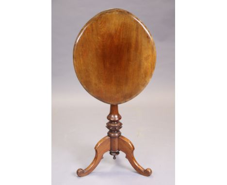 A Victorian mahogany tripod table with oval tilt-top, on turned centre column and three carved scroll legs, 39cm x 58cm x 71c