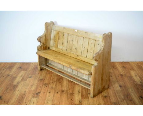 A vintage pine two-seater bench, the panelled backrest raised on shaped supports, united by foot stretchers, 130 x 47 x 88cm 