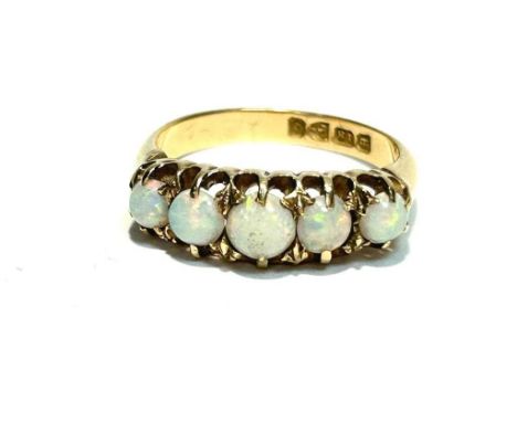 An opal ring, the five graduated circular opal cabochons in 18ct yellow gold mount and shank, hallmarked Chester 1899, ring s