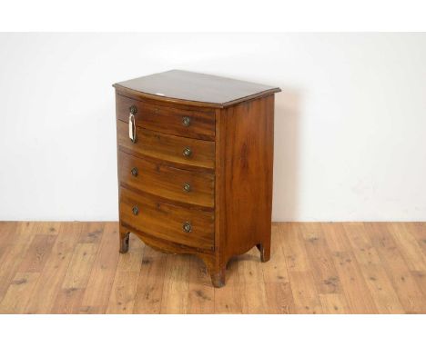 A Georgian style mahogany bow front chest of drawers of small size, the moulded edge top over four graduated drawers, raised 