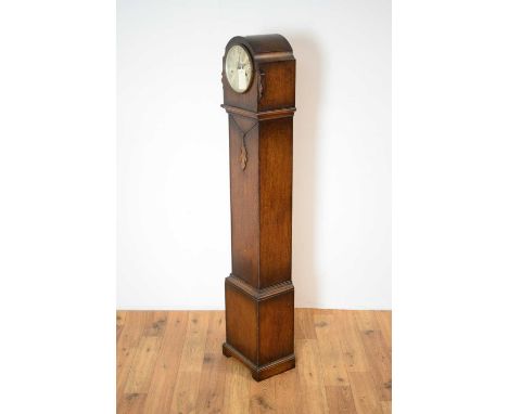 A 1930s oak chiming grandmother clock, the silvered dial with Arabic numerals, the waisted case with beaded motifs, panelled 