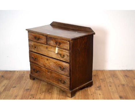 A Georgian mahogany chest of drawers with later stub gallery back, the rectangular top with moulded edge over two short and t