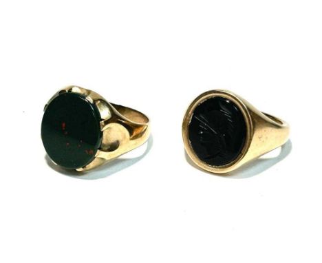 A blood stone signet ring on 9ct yellow gold shank, ring size U; together with an onyx signet ring carved with a helmeted war