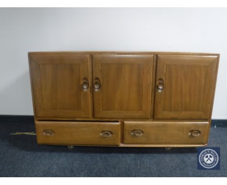 An Ercol elm triple door sideboard 