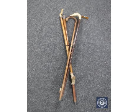 Five antique walking sticks together with a bag containing walking stick badges 