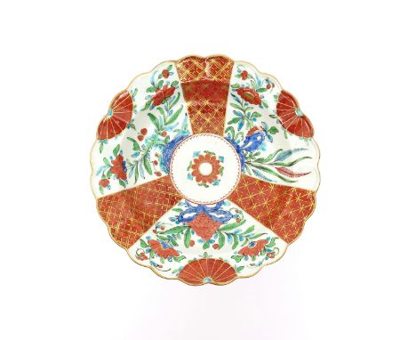 A Worcester scallop edged plate  c.1765, decorated in the Kakiemon palette with an unusual design of three panels of Oriental