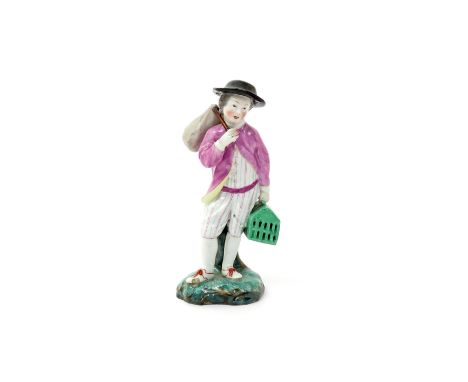 A Höchst figure of a boy c.1770, holding a green cage in his left hand, his right holding a travelling sack on a stick over h