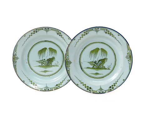 A pair of English delftware chargers   mid 18th century, each decorated in green monochrome with weeping willow issuing from 