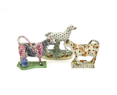 Two cow creamers  early 19th century, one decorated in Portobello type colours with a seated milkmaid to one side, raised on 