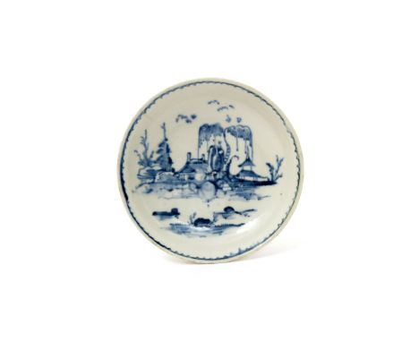 An early Vauxhall blue and white saucer  c.1755-58, painted with an Oriental landscape scene of low buildings beneath weeping