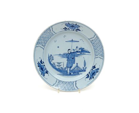 A good delftware plate  mid 18th century, finely potted and painted in blue with a standing Chinese figure holding a parasol 