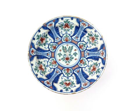An English delftware charger  c.1730, probably Lambeth, decorated in blue, green and red with a hexagonal motif around a cent