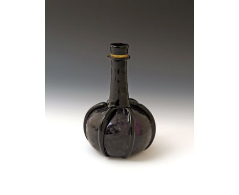 An amethyst glass decanter  18th century, of bottle form with a long tapering neck issuing from a squat globular body, applie