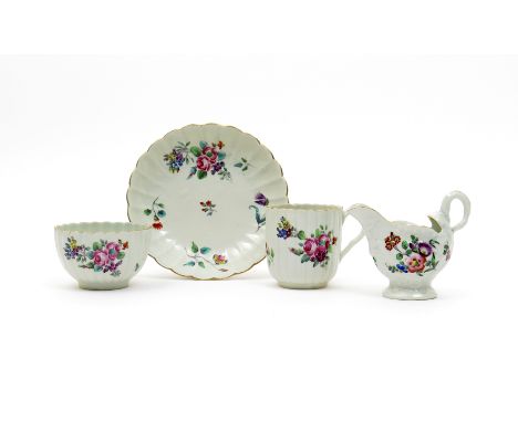 A Worcester trio  c.1770, the teabowl, coffee cup and saucer of fluted form and painted in polychrome enamels with flower spr